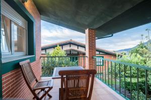 a patio with a table and chairs on a balcony at Villa La Perla De Sonabia in Oriñón