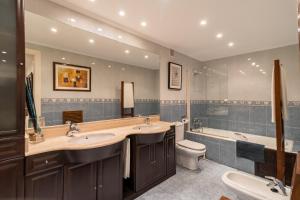 a bathroom with two sinks and a tub and a toilet at Villa La Perla De Sonabia in Oriñón +30 photos