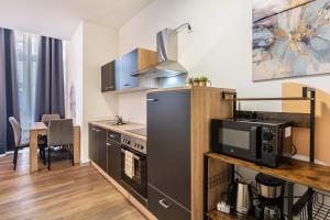 a small kitchen with a stove and a microwave at murihaus Ferienwohnung 2 in Aue