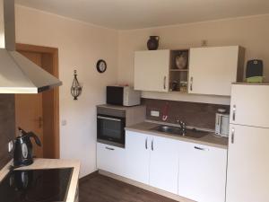 a kitchen with white cabinets and a sink at Ferienhaus Wiese in Olsberg