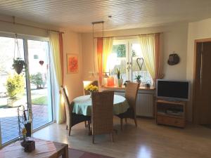 a dining room with a table with chairs and a television at Ferienhaus Wiese in Olsberg