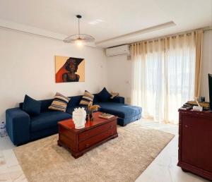 a living room with a blue couch and a table at Studio Al Wahat in Douar el Hafey