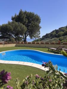 a large blue swimming pool with trees in the background at Tenuta Domine in Imperia