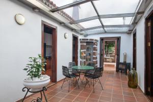 ein Wintergarten mit Tisch und Stühlen auf einer Terrasse in der Unterkunft Casa El Café in Las Tricias