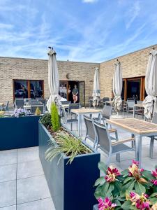 a patio with tables and chairs and umbrellas at Hotel Mezza Notte in Ronse