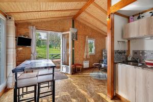 a kitchen and living room with a table and chairs at Chalet Sein Dans Parc Résidentiel in Pléneuf-Val-André