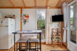 a kitchen with a table and a refrigerator and a tv at Chalet Sein Dans Parc Résidentiel in Pléneuf-Val-André +27 photos