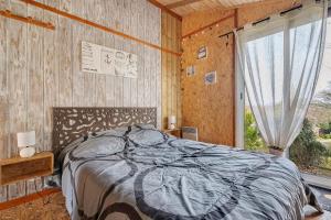 a bedroom with a bed and a large window at Chalet Sein Dans Parc Résidentiel in Pléneuf-Val-André