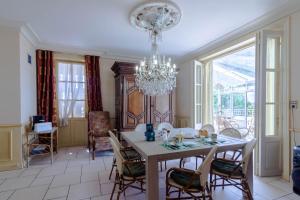 a dining room with a table and chairs and a chandelier at Chambre D'hôtes Vignols in Vignols