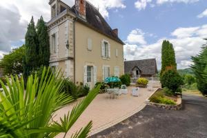 an old house with a patio in front of it at Chambre D'hôtes Vignols in Vignols