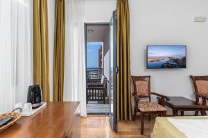 a hotel room with a bed and a table and chairs at Hotel Petrovac in Petrovac na Moru