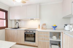 a kitchen with white cabinets and a stove top oven at Apartamento Bilua in Luanco