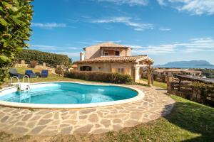 an outdoor swimming pool in front of a house at Villetta Caron in Olbia