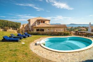 an outdoor swimming pool with chairs and a house at Villetta Caron in Olbia