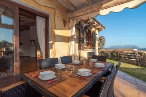 a wooden table and chairs on a patio at Villetta Caron in Olbia