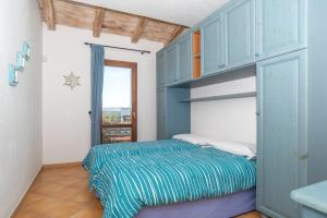 a bedroom with blue cabinets and a bed in it at Villetta Caron in Olbia