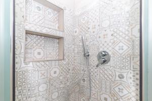 a bathroom with a shower with a tile wall at Villetta Caron in Olbia +25 photos