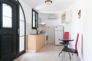 a kitchen with a black door and a table and chairs at Mani Tsopakas Residences Nest studio in Kafióna