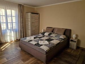 a bedroom with a bed with a quilt on it at Szilvaliget Vendégház in Tolcsva