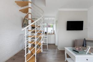 a spiral staircase in a living room with a couch at Häuschen Seerobbe in Böhl