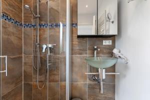 a bathroom with a sink and a shower at Häuschen Seerobbe in Böhl +15 photos