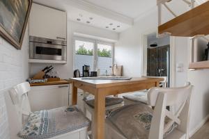 a kitchen with a table and chairs in a kitchen at Häuschen Seerobbe in Böhl