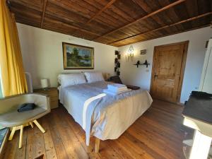 a bedroom with a large bed and a chair at La Torre Medievale in Triora