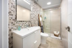 a white bathroom with a sink and a toilet at Capricho Torre del mar in Torre del Mar
