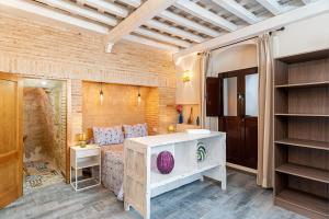 a bedroom with a bed and a brick wall at Rosa in Vejer de la Frontera