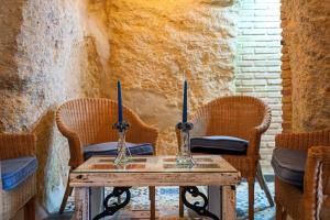 two candles on a wooden table with two chairs at Rosa in Vejer de la Frontera