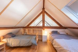 two beds in a room with a roof at Chalet Confortable 14 voyageurs in Urdos