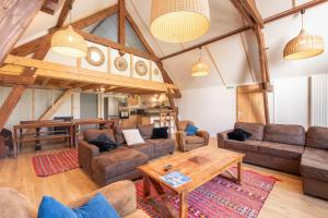 a living room with couches and a table at Chalet Confortable 14 voyageurs in Urdos