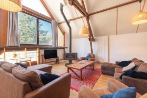 a large living room with couches and a tv at Chalet Confortable 14 voyageurs in Urdos
