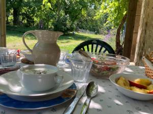 a table with a cup and plates of food on it at Chez Bonneau in Nantiat +10 photos