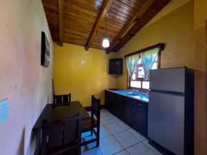 a kitchen with a refrigerator and a table and chairs at Cabañas Rosy in Mazamitla +13 photos