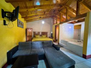 a bedroom with a couch and a bed and a tub at Cabañas Rosy in Mazamitla