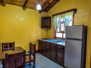 a kitchen with a white refrigerator and a table at Cabañas Rosy in Mazamitla