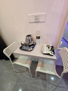 a table with two chairs and a tea kettle on it at Tazinn in Wayanad +61 photos