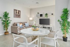 a living room with a white table and a couch at Aptos Turísticos Playa Marinsa in Torre del Mar