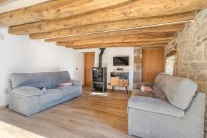 a living room with two couches and a tv at El Molí de Can Feliu in Navés +18 photos