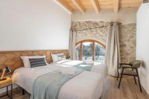 two beds in a room with a window at El Molí de Can Feliu in Navés