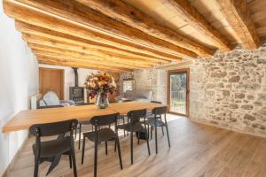 a dining room with a large wooden table and chairs at El Molí de Can Feliu in Navés