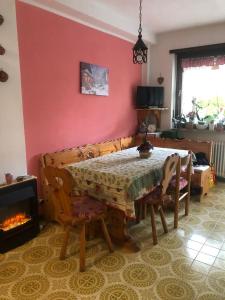 a dining room with a table and a fireplace at L'oasi dei larici - Montoso in Bagnolo Piemonte