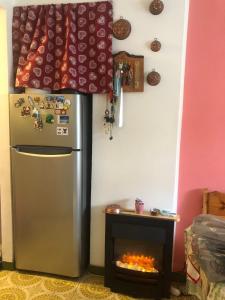 a refrigerator and a fireplace in a room at L'oasi dei larici - Montoso in Bagnolo Piemonte
