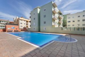 a swimming pool in front of a building at Apartamento Gabriela in Candelaria