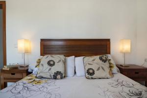a bedroom with a bed with pillows and two lamps at Serendipity in Playa Blanca