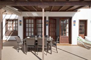 a dining table and chairs on a patio at Serendipity in Playa Blanca