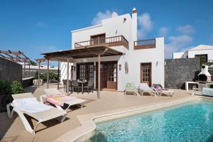 a villa with a swimming pool and a house at Serendipity in Playa Blanca