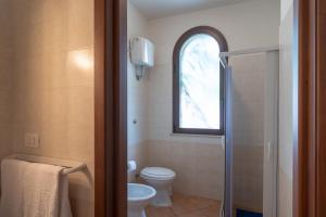 a bathroom with a toilet and a window at Monolocale 900 in Racale