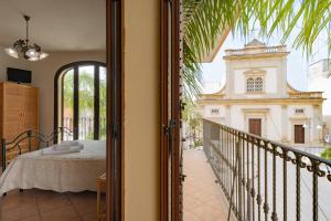 a room with a bed and a balcony with a building at Monolocale 900 in Racale